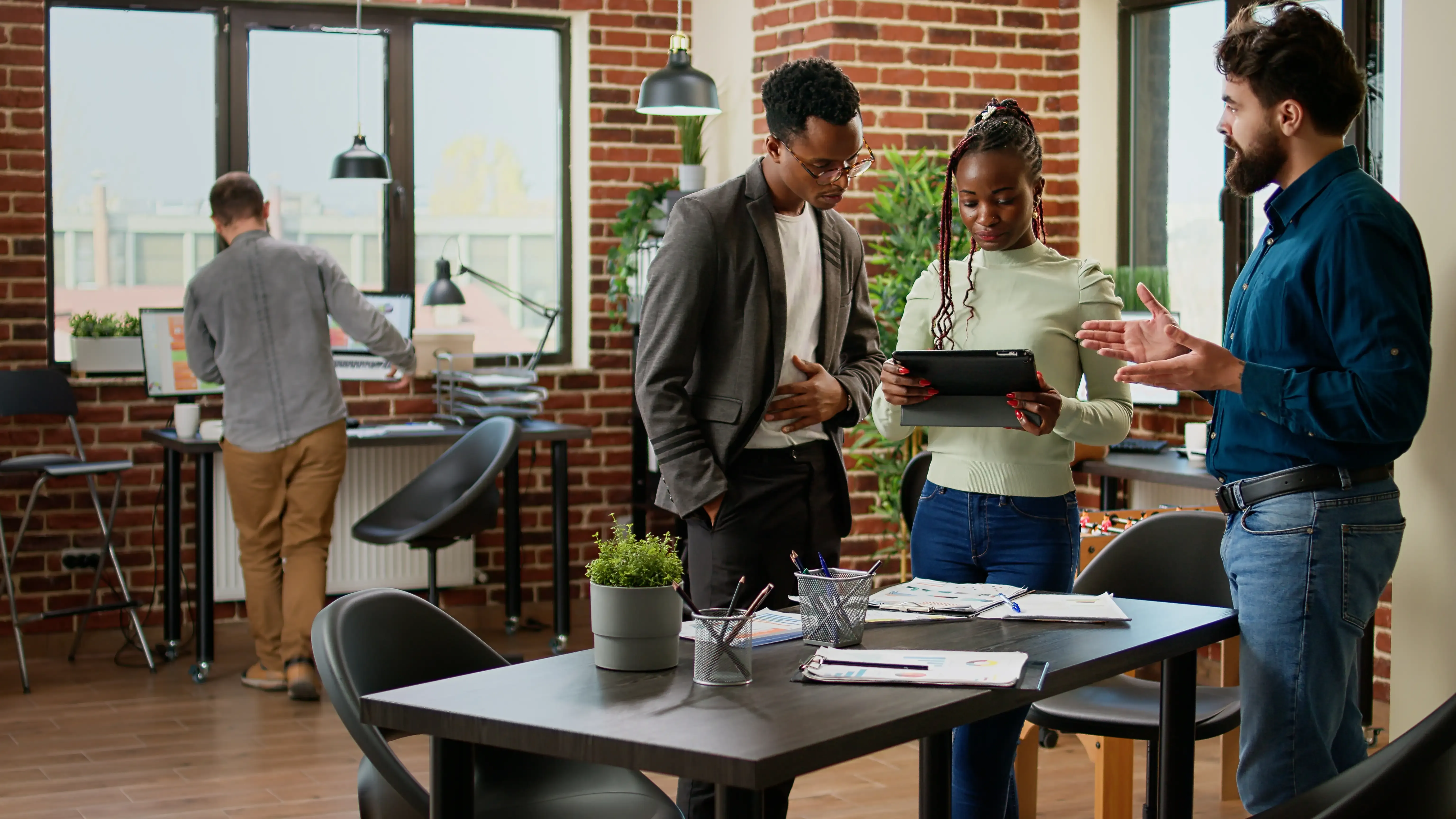 A team reviewing work together on a tablet in an office
